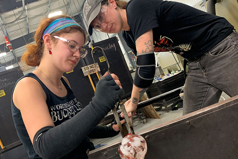 Two women blowing glass