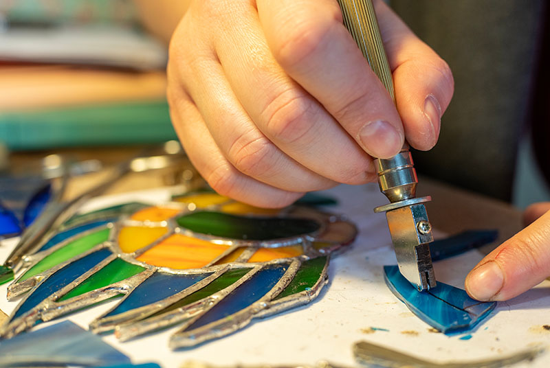 Close up of a hand cutting glass for creating stained glass