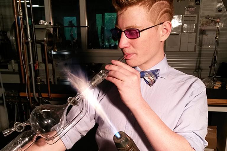 Artist and scientific glassblower, Lucas Clarke, working on glass at the torch