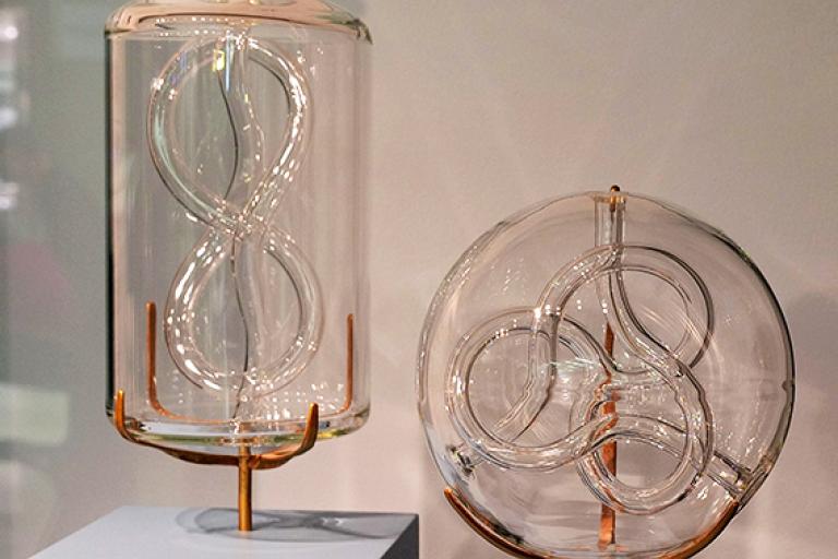 Two sculptures by Lucas Clarke with winding tubes inside larger glass vessels