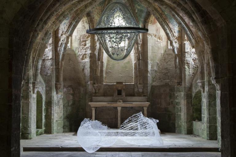 Installation artwork by Kim KototamaLune inside a stone dome shaped room with glass handing from the ceiling and laying on the floor