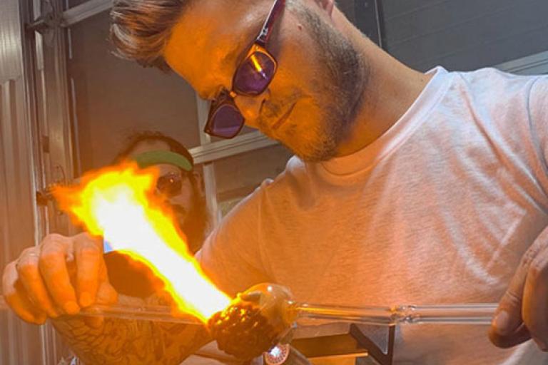 Artist Danny White sculpting glass on a torch