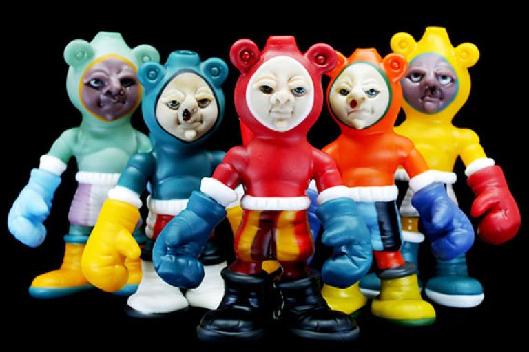 Sculpture of five colorful glass figures wearing hoods a boxing gloves by Danny White