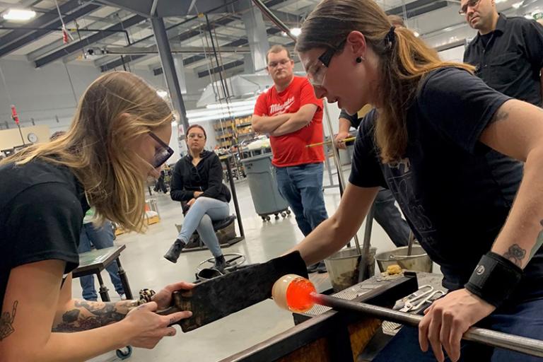 Image of artist Patty Clune working with hot glass