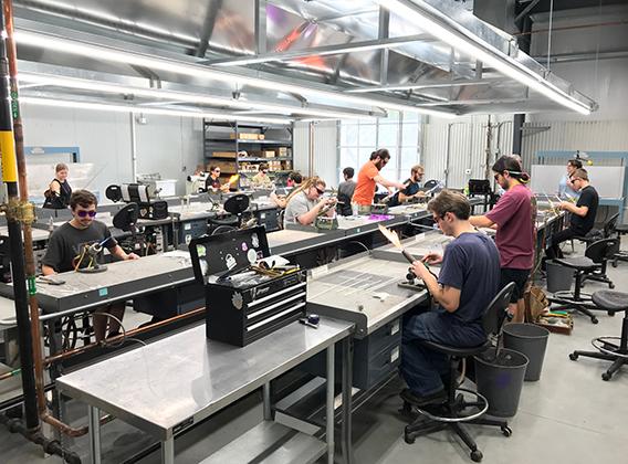 Students working in the flameworking studio area