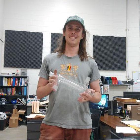 Robin Degroof, Graduate of Scientific Glass Technology, holding a piece of scientific glass apparatus