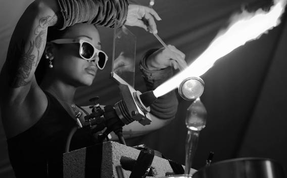 A woman working glass at a torch