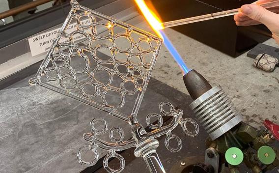 Glass sculptural object being worked on with a glassmaking torch